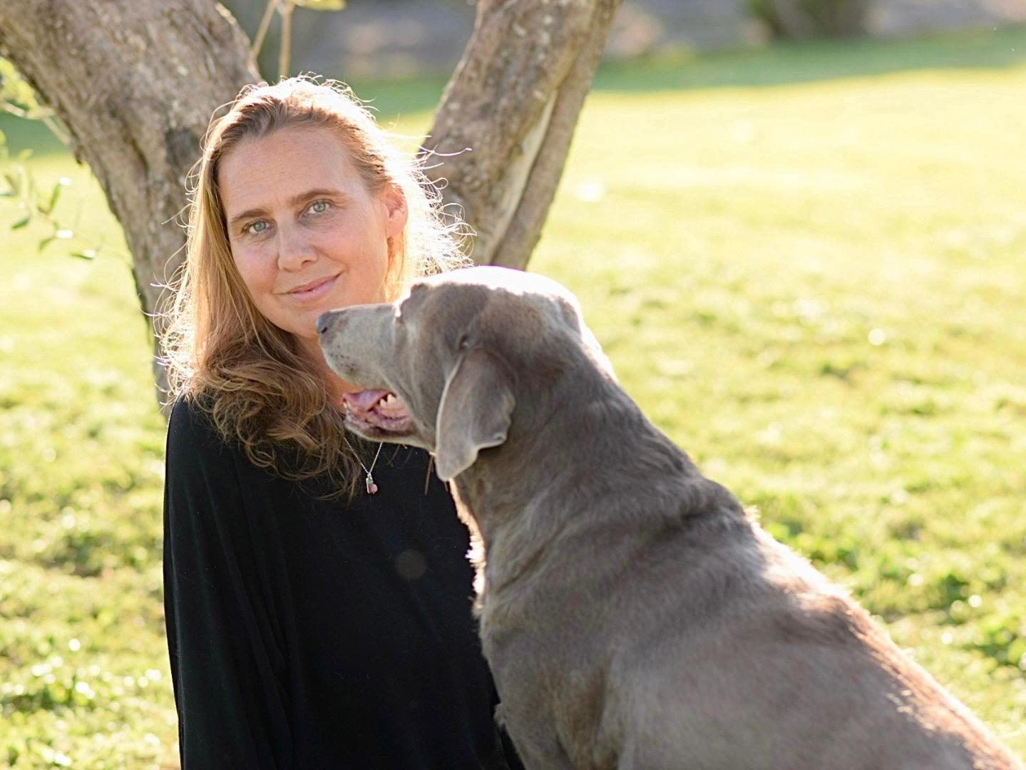 Andrea Röker mit ihrem Weimaraner unter einem Baum